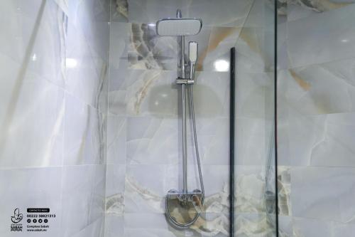 a glass shower with a shower head in a bathroom at Sabah Resort Nouakchott in Nouakchott