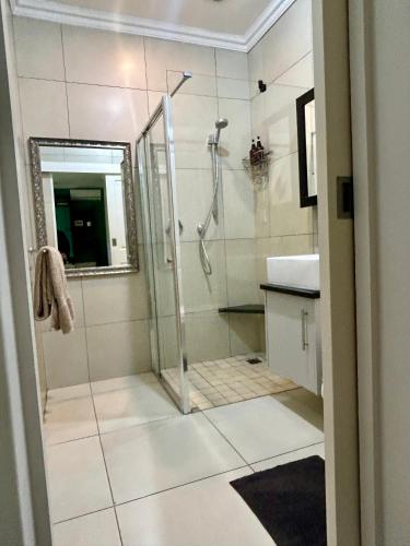 a bathroom with a shower and a sink and a mirror at Bamboo in George