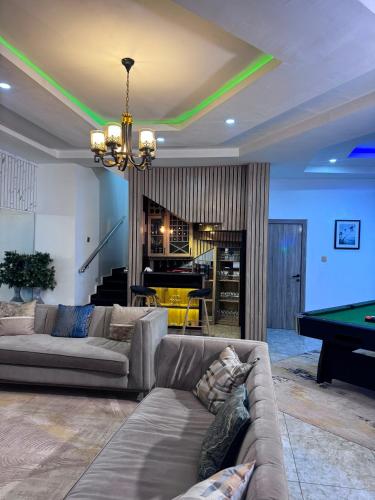 a living room with a couch and a pool table at Stone and Beam apartment in Abuja