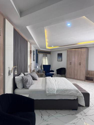 a bedroom with a large bed and a living room at Stone and Beam apartment in Abuja