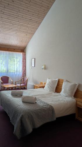 a bedroom with a large bed and a table and chairs at La Cascade in Vernayaz