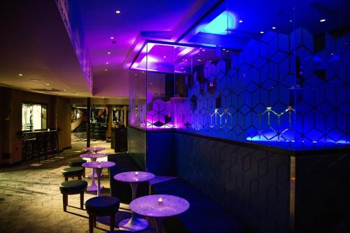 a bar with purple lighting and stools at Malmaison Manchester in Manchester