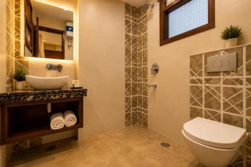 a bathroom with a sink and a toilet and a mirror at Hotel Nayyar Inn Near Golden temple in Amritsar