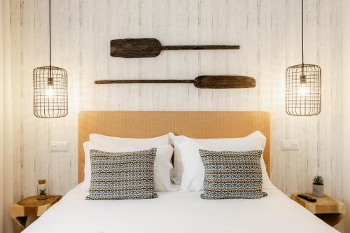 a bedroom with a white bed with two pillows at Shellter Apartments by the sea in Vieira de Leiria