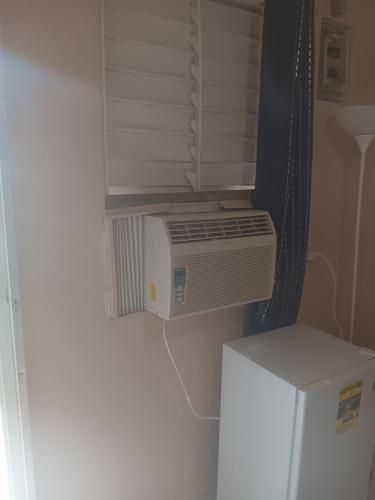 a small kitchen with a heater and a refrigerator at Studio comodo con aire acondicionado in Caguas