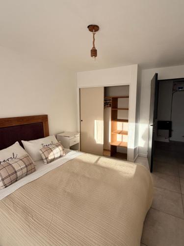 a white bedroom with a large bed with pillows at DUPLEX Parque in Azul