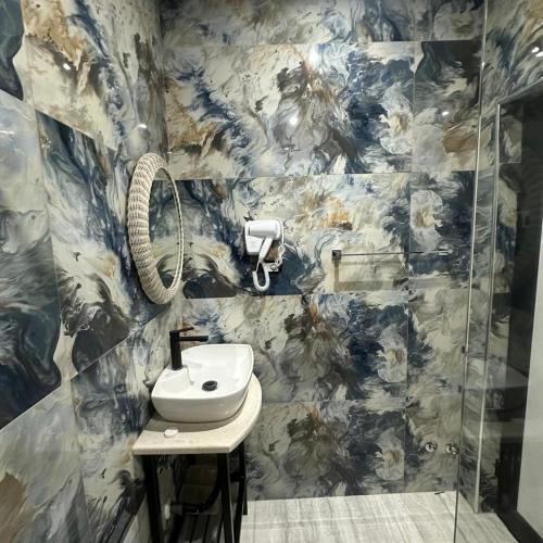 a bathroom with a sink and a phone on the wall at Kremelo Hotel in Berat