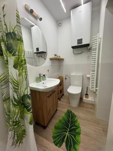 a bathroom with a sink and a toilet and a mirror at Domek M5 w centrum Wiela in Wiele