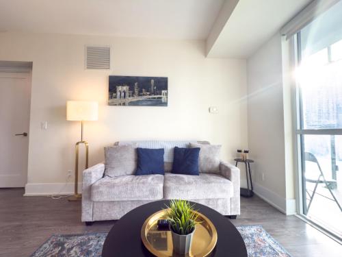 a living room with a couch and a table at Central City Suites with Free Parking in Toronto