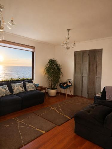 a living room with a couch and a large window at Casa Vista Pacífico in Concón
