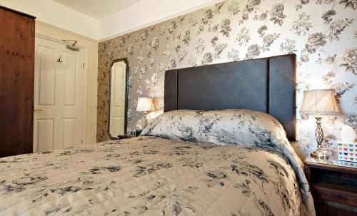 a bedroom with a large bed with floral wallpaper at Bronte Guest House in York