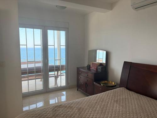 a bedroom with a bed and a balcony with the ocean at Haus am Strand in Bar
