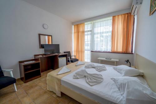 a hotel room with a bed and a television at Hotel Callatis in Neptun