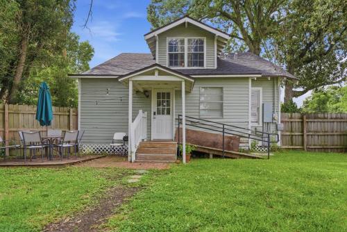 a white house with a fence and a yard at Group-Ready 6BR Gem in Central Lafayette in Lafayette