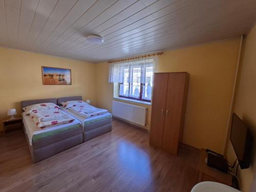 a small bedroom with two beds and a window at Pension Chalupka l with a panoramic view of Spiš Castle in Spišské Podhradie