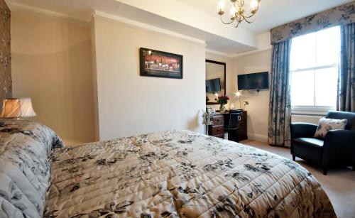 a bedroom with a bed and a chair and a window at Bronte Guest House in York