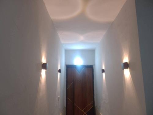 a hallway with a door and lights on a wall at Abu sobh holiday in Alexandria