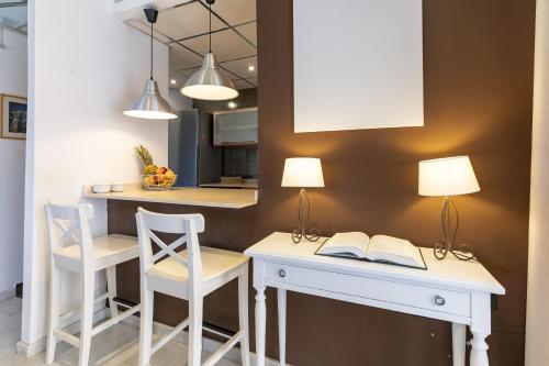 a kitchen with a desk with a book and two chairs at Sunny Holidays Mojácar Pool House in Mojácar