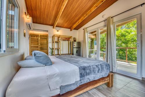 a bedroom with a large bed with blue pillows at Bocas Stoked Monkeys in Bocas Town