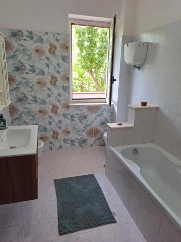 a bathroom with a tub and a sink and a window at Villa Anna Tropea in Tropea