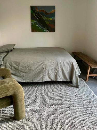 a bedroom with a bed and a wooden table at Oasis in onerahi in Whangarei