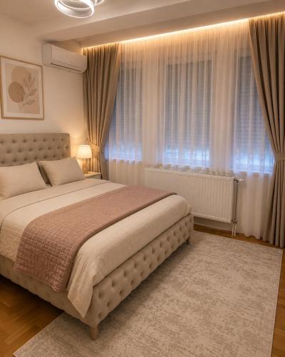 a bedroom with a large bed in front of a window at AS Lux apartment tetovo in Tetovo