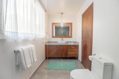a bathroom with a sink and a toilet and a mirror at Area 101 in Playa Pelada