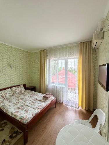 a small bedroom with a bed and a window at Hotel Elion in Zatoka