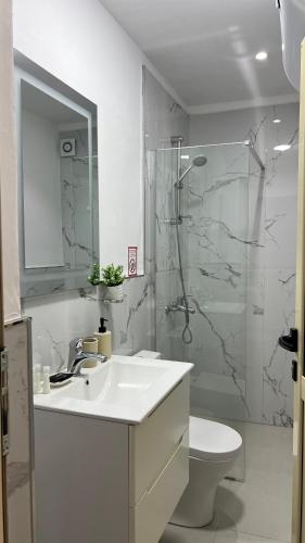 a bathroom with a sink and a shower and a toilet at Kloa Apartments in Orikum