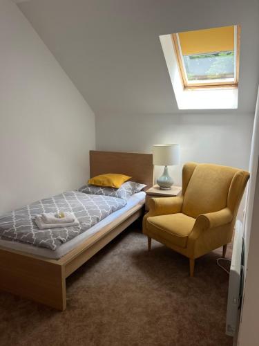 a bedroom with a bed and a chair at Penzion Richnava in Štiavnické Bane