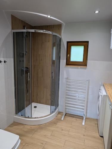 a bathroom with a shower and a toilet in it at Sielski Domek Na Wzgórzu in Sulęczyno