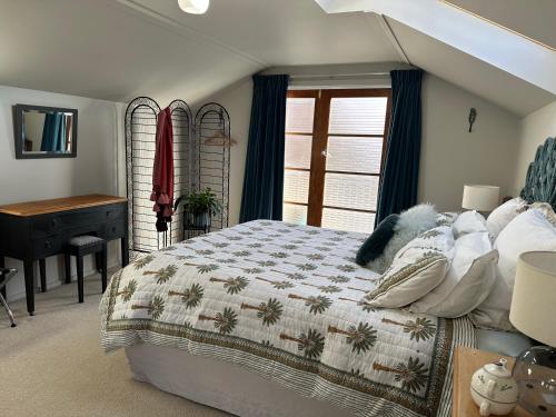 a bedroom with a bed and a desk and a window at Loft on Blyth in Clyde