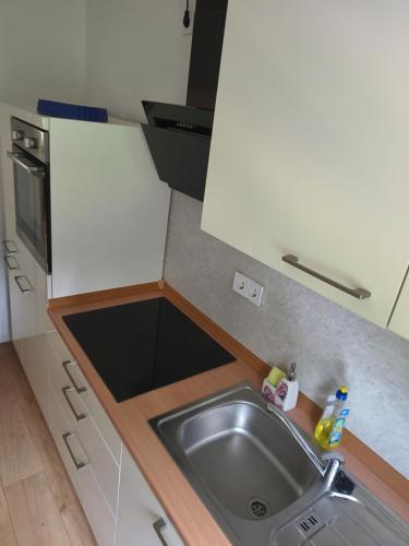 a kitchen counter with a sink and a microwave at Schickes Apartment in Herten