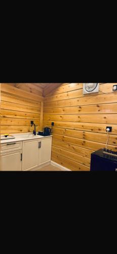a kitchen with wooden walls and a counter top at اكواخ اليمامة in Al Baha