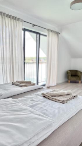 two white beds in a room with a window at Koło Wody - dom dla 6 osób in Sadków