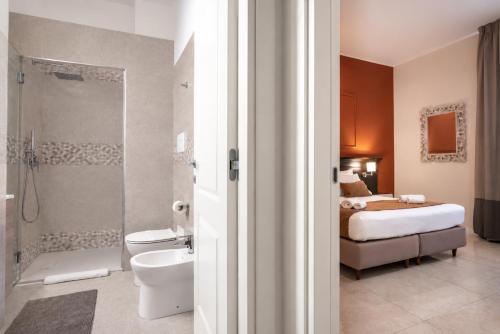 a bathroom with a bed a toilet and a shower at Ad Maiora Elegant Rooms in Palermo