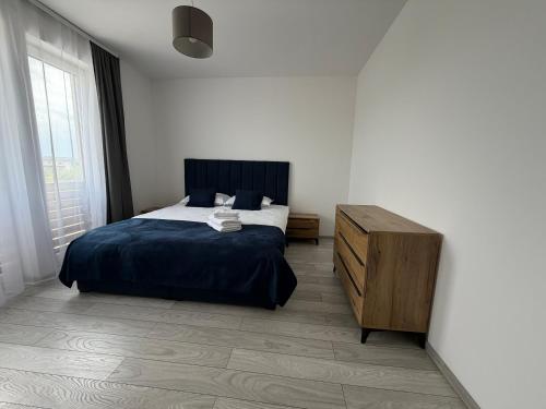 a bedroom with a bed and a wooden dresser at Concept Residence in Târgu-Mureş