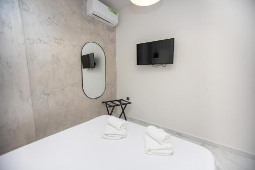 a room with a bed with a mirror and a tv at Room12 in Stavros