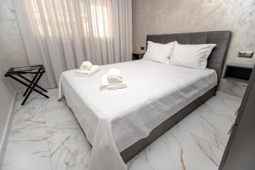 a bedroom with a white bed with towels on it at Room12 in Stavros