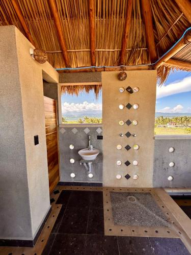 a bathroom with a sink and a view of a field at Condominio Agave del Mar in Coyuca