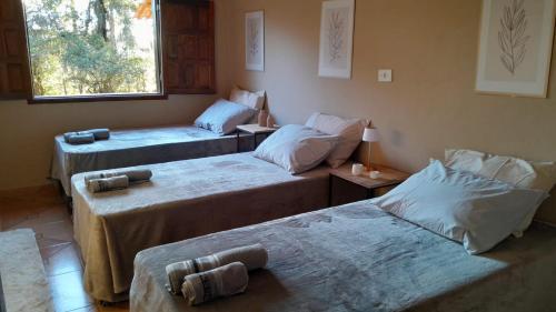 a room with three beds and a window at Pousada Santa Rita in Amarantina