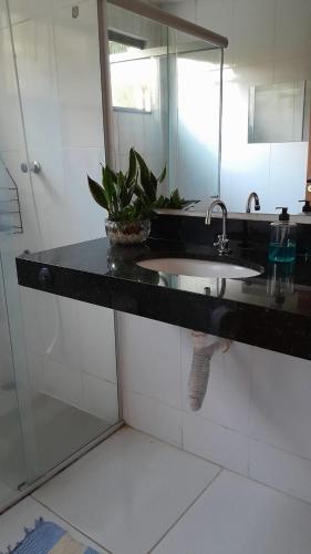 a bathroom counter with a sink and a mirror at Pousada Santa Rita in Amarantina