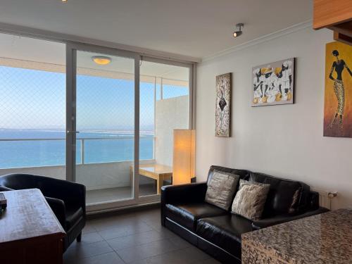 a living room with a couch and a view of the ocean at Oceana Suites Costa Montemar in Concón