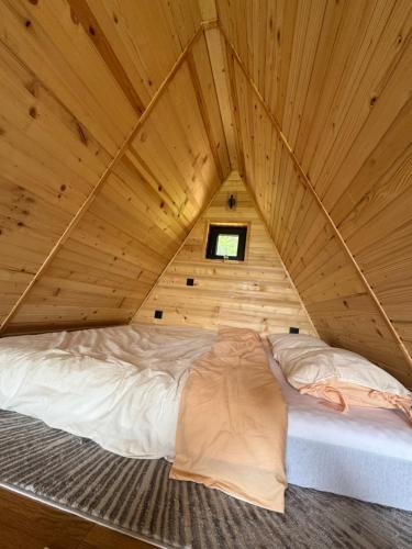 a bed in a wooden room with a roof at Theforestheaven in Brđani