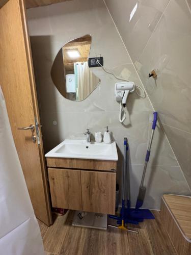 a bathroom with a sink and a mirror and a mop at Theforestheaven in Brđani