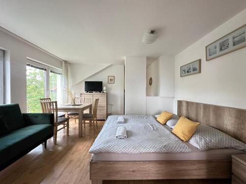 a bedroom with a bed and a couch and a table at Above Apartments in Liptovský Mikuláš