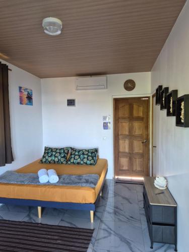 a bedroom with a bed and a table and a door at Fare Hanihau in Uturoa