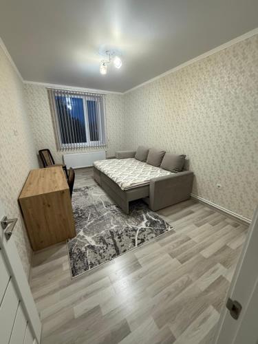 a living room with a bed and a table at Квартира в центре города in Komrat