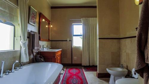 uma casa de banho com uma banheira, um lavatório e um WC. em Sweet Dreams Guest House em Melkbosstrand