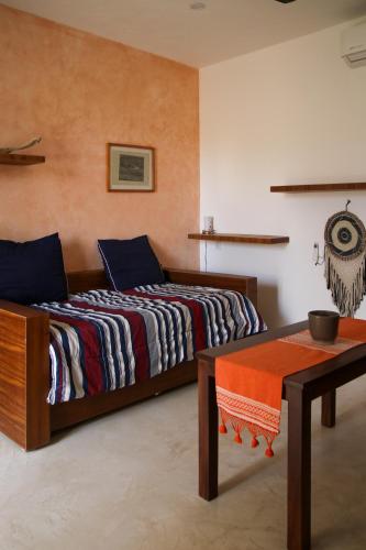 a bedroom with two beds and a table at Casa Maracuyá Chacala in Chacala